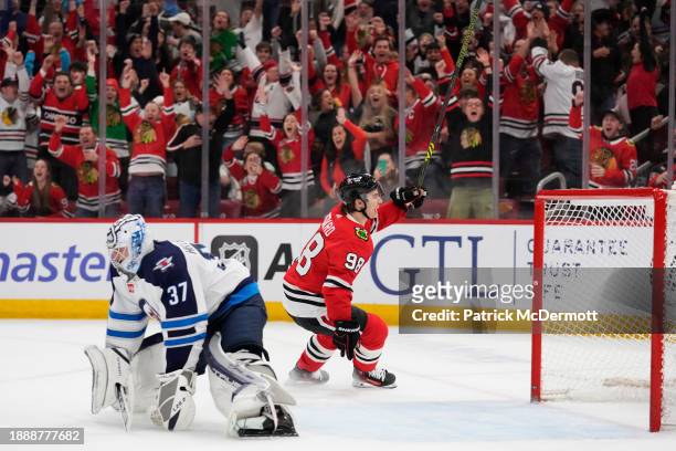 Connor Bedard of the Chicago Blackhawks celebrates after scoring the game winning goal against Connor Hellebuyck of the Winnipeg Jets during overtime...