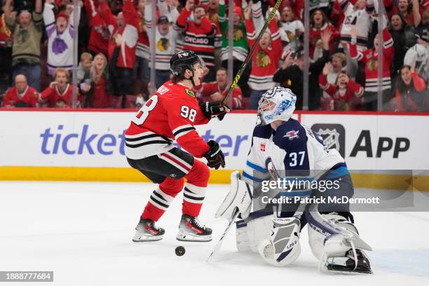 Connor Bedard of the Chicago Blackhawks celebrates after scoring the game winning goal against Connor Hellebuyck of the Winnipeg Jets during overtime...