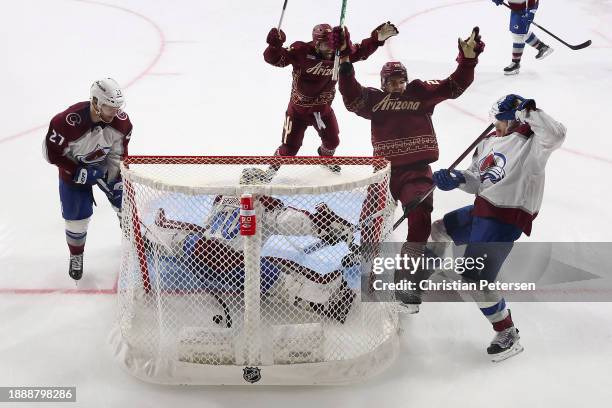 Jack McBain of the Arizona Coyotes celebrates alongside Jason Zucker after scoring the game-winning goal past goaltender Alexandar Georgiev of the...