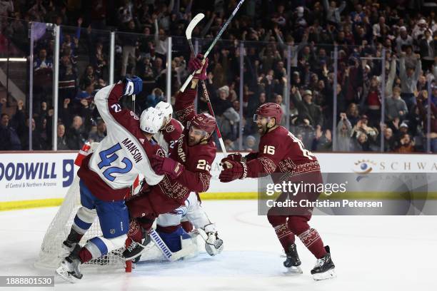 Jack McBain of the Arizona Coyotes celebrates alongside Jason Zucker after scoring the game-winning goal past goaltender Alexandar Georgiev of the...