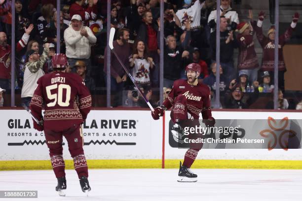 Jason Zucker of the Arizona Coyotes celebrates with Sean Durzi after scoring a goal against the Colorado Avalanche during the third period of the NHL...
