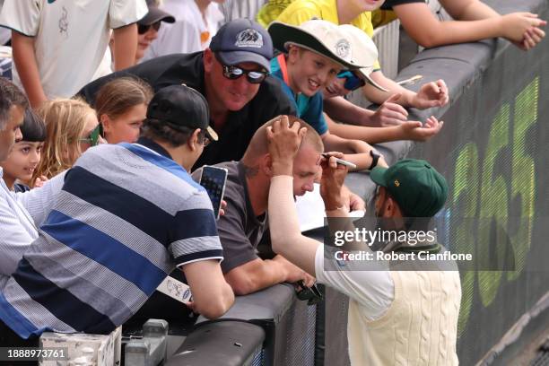 Hasan Ali of Pakistan signs his autograph on a spectators headduring day three of the Second Test Match between Australia and Pakistan at Melbourne...