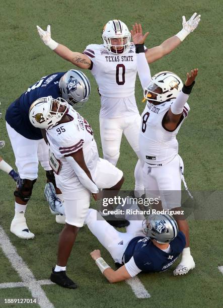 Defensive tackle Terry Webb, linebacker Brian Holloway, and defensive end Jordan Revels of the Texas State Bobcats celebrate after sacking...