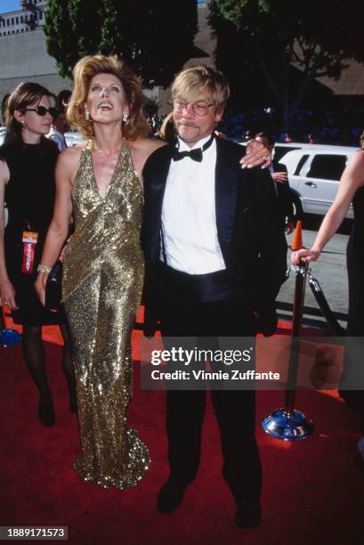 American actress and singer Christine Baranski, wearing a gold halterneck evening gown, and her husband, American actor and playwright Matthew...