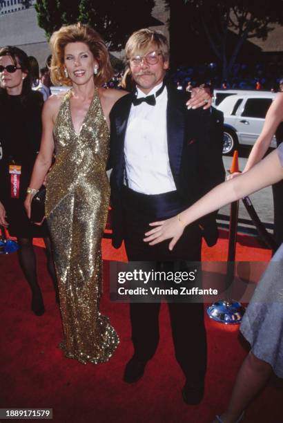 American actress and singer Christine Baranski, wearing a gold halterneck evening gown, and her husband, American actor and playwright Matthew...