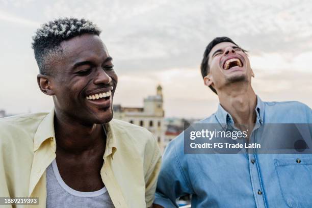 friends talking and laughing on the rooftop - two friends laughing stock pictures, royalty-free photos & images