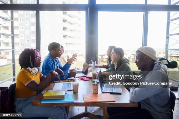 group of diverse college students studying around a cafeteria table - high school cafeteria stock pictures, royalty-free photos & images