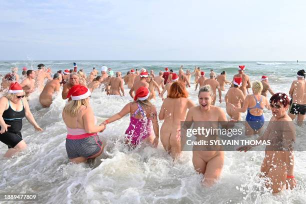 Graphic content / People take part in a traditional sea bath to mark the New Year's celebrations on a nudist beach in Le Cap d'Agde, southern France,...