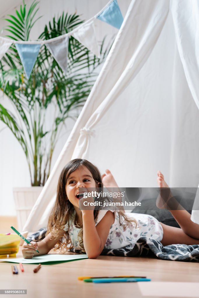 Girl at home painting and reading book at children's room