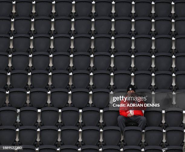 Fulham fan wearing an England shirt takes his seat in the grandstand for the English Premier League football match between Fulham and Arsenal at...