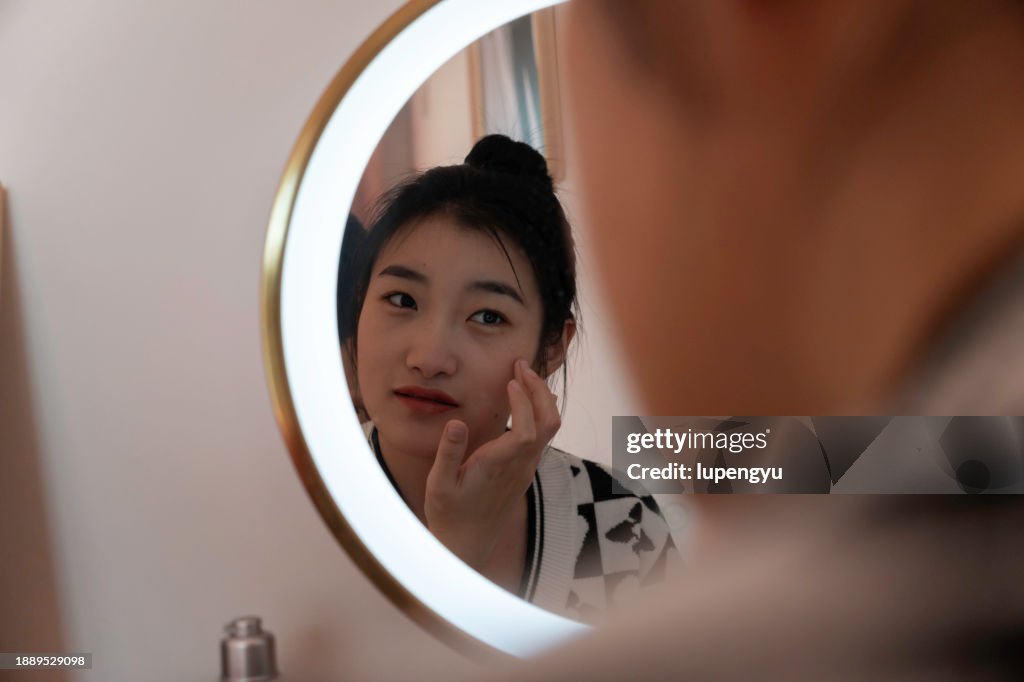 An asian woman making up