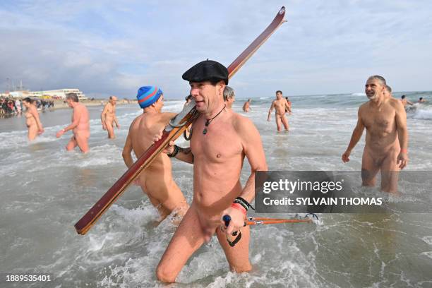 Graphic content / People take part in a traditional sea bath to mark the New Year's celebrations on a nudist beach in Le Cap d'Agde, southern France,...