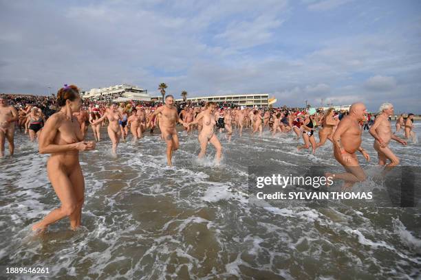 Graphic content / People take part in a traditional sea bath to mark the New Year's celebrations on a nudist beach in Le Cap d'Agde, southern France,...