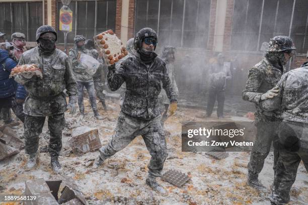 Revelers take part in the 'Enfarinats' battle, a flour, egg and pyrotechnics fight to celebrate the Els Enfarinats festival on December 28, 2023 in...