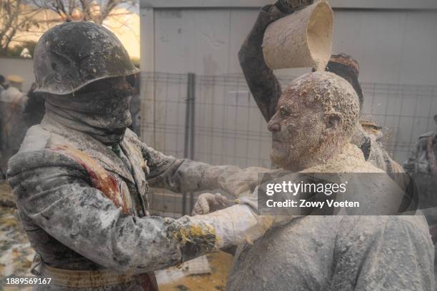 Revelers take part in the 'Enfarinats' battle, a flour, egg and pyrotechnics fight to celebrate the Els Enfarinats festival on December 28, 2023 in...