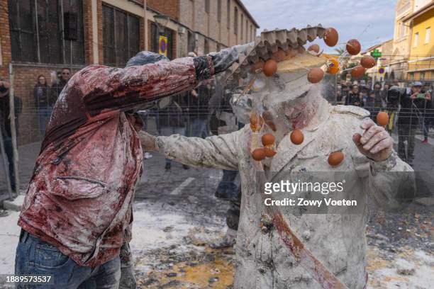 Revelers take part in the 'Enfarinats' battle, a flour, egg and pyrotechnics fight to celebrate the Els Enfarinats festival on December 28, 2023 in...