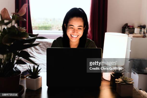 young adult woman remote working on laptop from home office, bristol, england, united kingdom - zoom meeting stock pictures, royalty-free photos & images