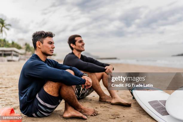 young surfer man contemplating while looking away on the beach - practice gratitude stock pictures, royalty-free photos & images