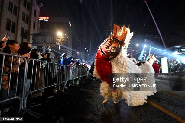 South Korean traditional dancers perform during a parade as part of a countdown event to mark the New Year in central Seoul before midnight on...