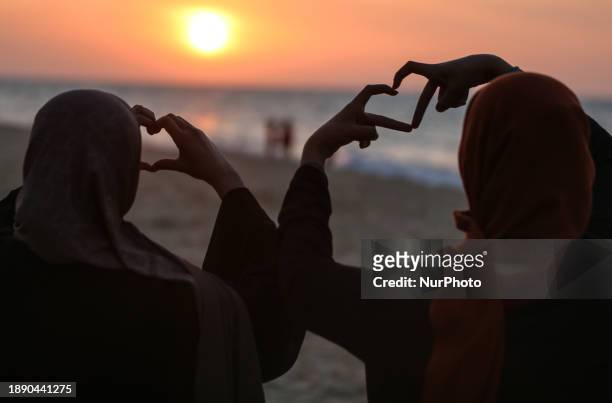 Palestinians are enjoying the last sunset of the year in Deir al-Balah, in the central Gaza Strip, on December 31 amid the ongoing conflict between...