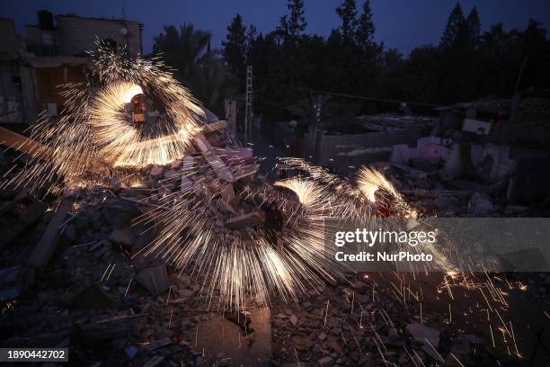 Palestinians are lighting fireworks above the rubble of a building that was destroyed by Israeli bombing in Deir al-Balah, central Gaza Strip, on the...