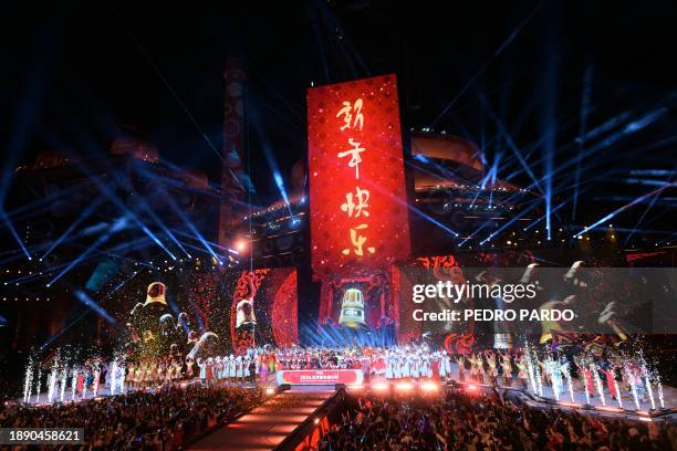 Glitter cannons and pyrotechnics erupt as revellers celebrate the New Year during a countdown event in Beijing, on December 31, 2023.