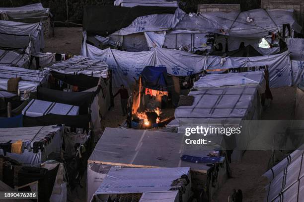 The tent camps of displaced Palestinians are pictured in Rafah in the southern Gaza Strip close to the border with Egypt after sunset on December 31,...