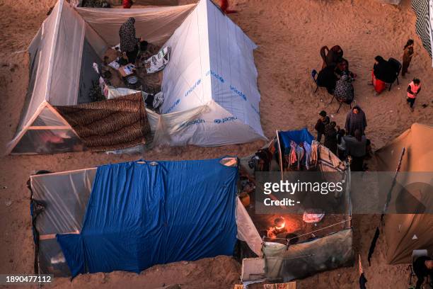 The tent camps of displaced Palestinians are pictured in Rafah in the southern Gaza Strip close to the border with Egypt at sunset on December 31,...