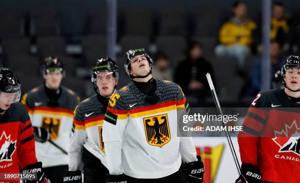 Germany's forward Lennard Nieleck and team mates react after the Group A ice hockey match between Canada and Germany of the IIHF World Junior...