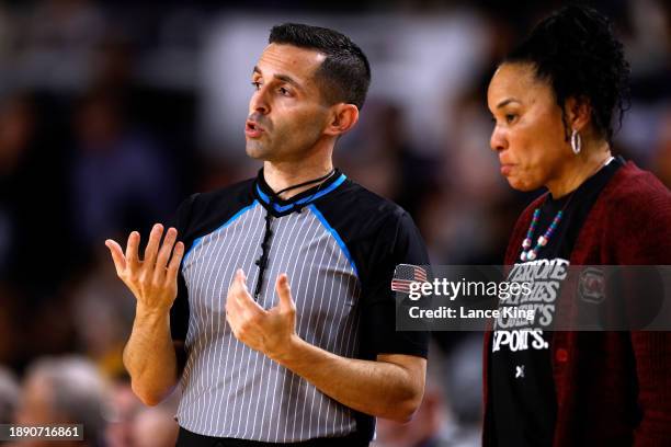 Official John Capolino explains a call to head coach Dawn Staley of the South Carolina Gamecocks during the game against the East Carolina Lady...