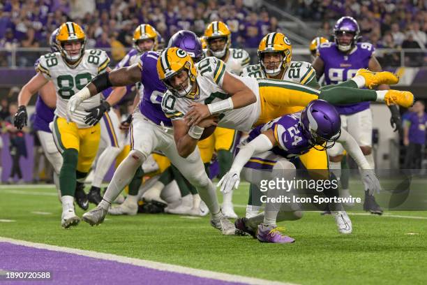 Green Bay Packers quarterback Jordan Love leaps over Minnesota Vikings defensive back Camryn Bynum to score a touchdown from 2-yards out during the...