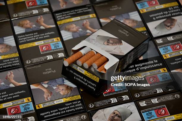 In this photo illustration, cigarettes appear from an open pack and placed on top of other closed packs of cigarettes. From January 1 most packs of...
