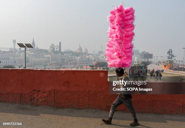 Candy floss seller walks near the banks of the river Saryu in Ayodhya. Ayodhya is an ancient city in northern India that has great religious and...
