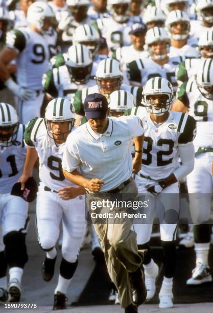 Head Coach Herman Edwards wears an FDNY baseball cap as he leads the team to the field in the first game following the September 11 Attacks in the...