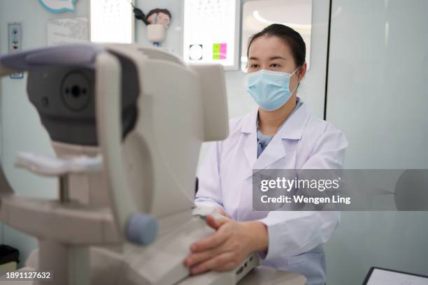 doctor using eye testing equipment - retinal scan stock pictures, royalty-free photos & images