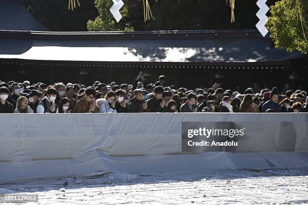 People pray and throw coins to offer prayers for the New Year at the Meiji Shrine on January 1st, 2024 in Tokyo, Japan. Japanese go to Shrine to...