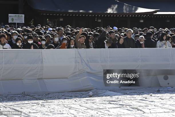 People pray and throw coins to offer prayers for the New Year at the Meiji Shrine on January 1st, 2024 in Tokyo, Japan. Japanese go to Shrine to...