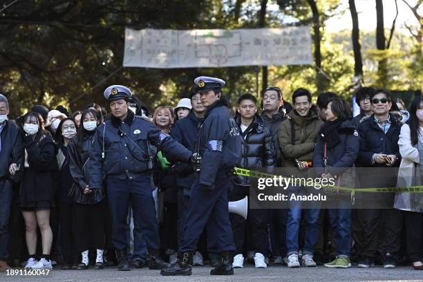 People wait at the main entrance of the Meiji Shrine as they go to pray for the New Year at the Shrine on January 1st, 2024 in Tokyo, Japan. Japanese...