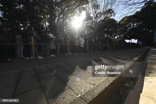 People walk at the main entrance of the Meiji Shrine as they go to pray for the New Year at the Shrine on January 1st, 2024 in Tokyo, Japan. Japanese...