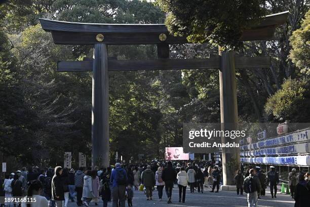 People walk at the main entrance of the Meiji Shrine as they go to pray for the New Year at the Shrine on January 1st, 2024 in Tokyo, Japan. Japanese...