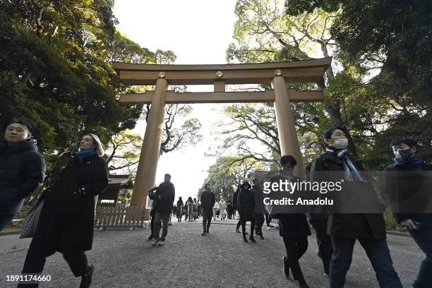 People walk at the main entrance of the Meiji Shrine as they go to pray for the New Year at the Shrine on January 1st, 2024 in Tokyo, Japan. Japanese...