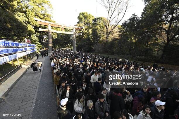 People walk at the main entrance of the Meiji Shrine as they go to pray for the New Year at the Shrine on January 1st, 2024 in Tokyo, Japan. Japanese...