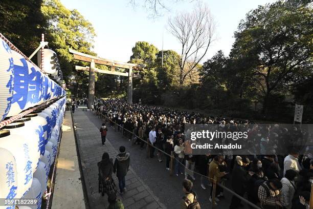 People walk at the main entrance of the Meiji Shrine as they go to pray for the New Year at the Shrine on January 1st, 2024 in Tokyo, Japan. Japanese...