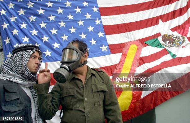 Demonstrators are seen protesting the US-led war in Iraq 12 April 2003 in Mexico City. Dos actores de teatro realizan una performanse frente a una...