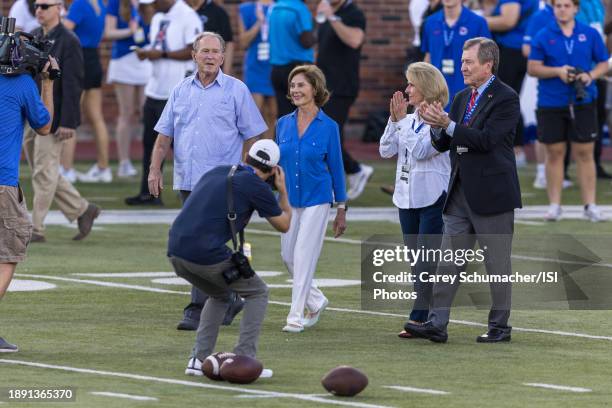 President George W. Bush and Laura Bush walk towards the coin toss during a game between Charlotte and Southern Methodist University at Gerald J Ford...