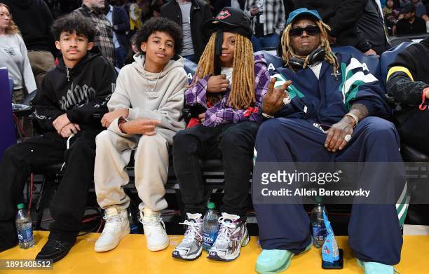 Dwayne Carter III, Kameron Carter, Neal Carter and Lil Wayne attend a basketball game between the Los Angeles Lakers and the Charlotte Hornets at...