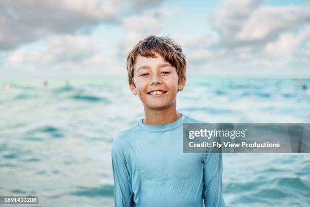 portrait of young boy in the ocean - tweens in bathing suits stock pictures, royalty-free photos & images