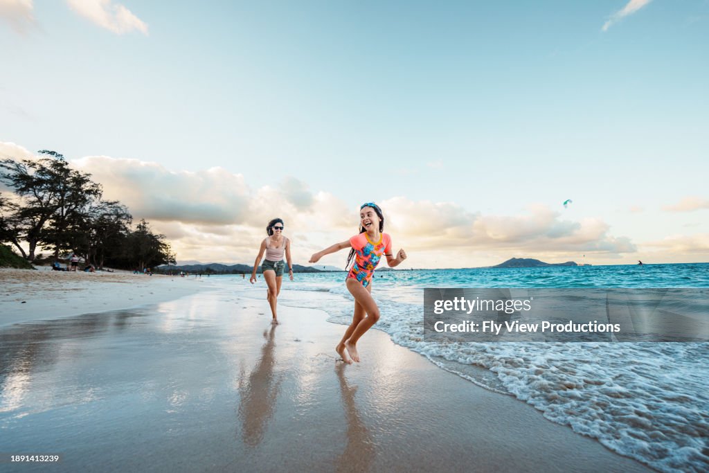 Mother and daughter play on the beach