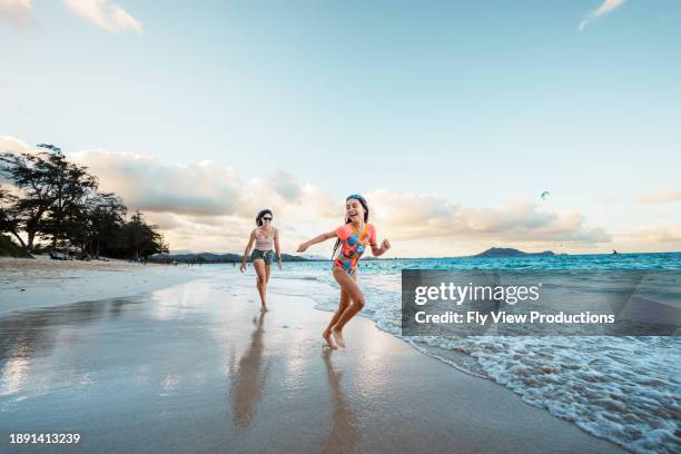 mother and daughter play on the beach - pacific ocean stock pictures, royalty-free photos & images