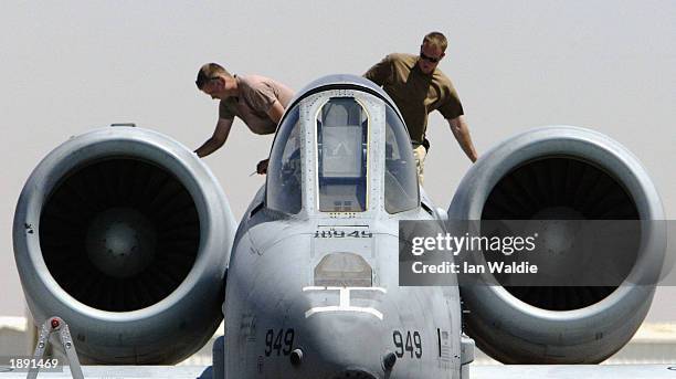 Airforce ground maintainence crewmen check over the engines of an A10 Thunderbolt "Warthog" after it had returned from a mission April 2 at an air...